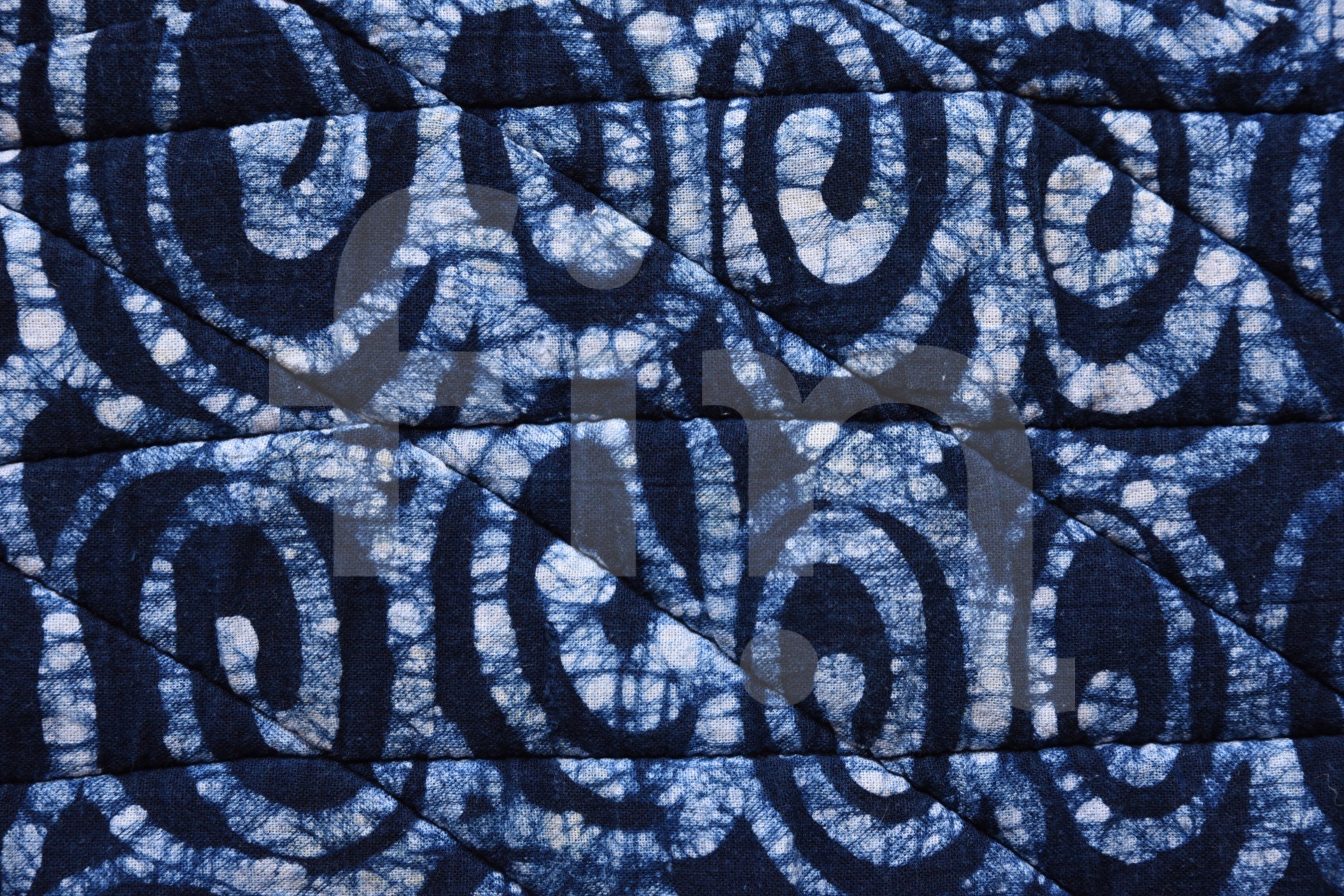 Blue and white ornaments with stitched lines on the textile