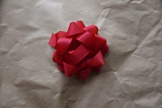 Texture of brown beige color paper with red bow