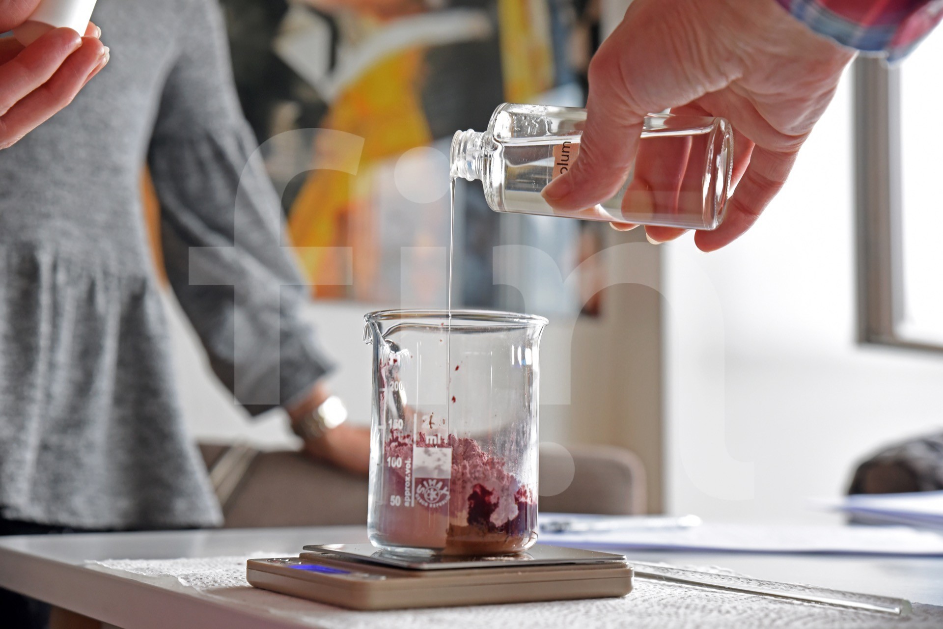 Education in natural cosmetic workshops pouring glycerin into a glass