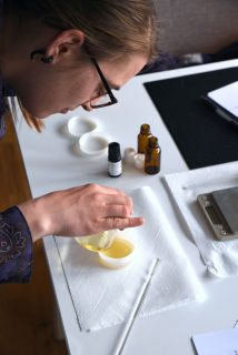Girl at a natural cosmetics workshop pouring oil