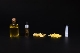 Ingredients for natural cosmetics oils cacao butter on a black background