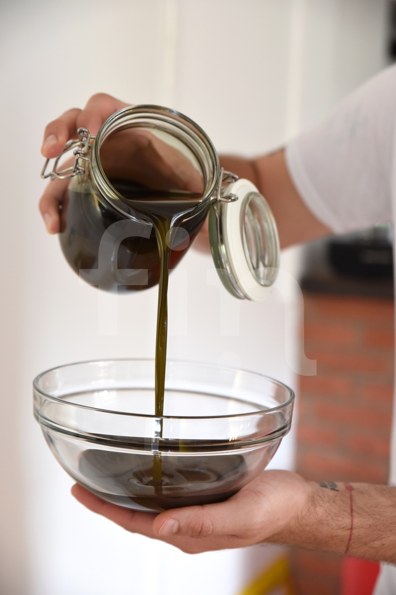 Pouring macerate oil hand holding the bowl