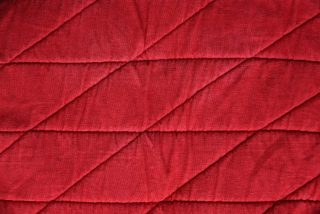 Red textile texture with stitched horizontal rhombuses texture