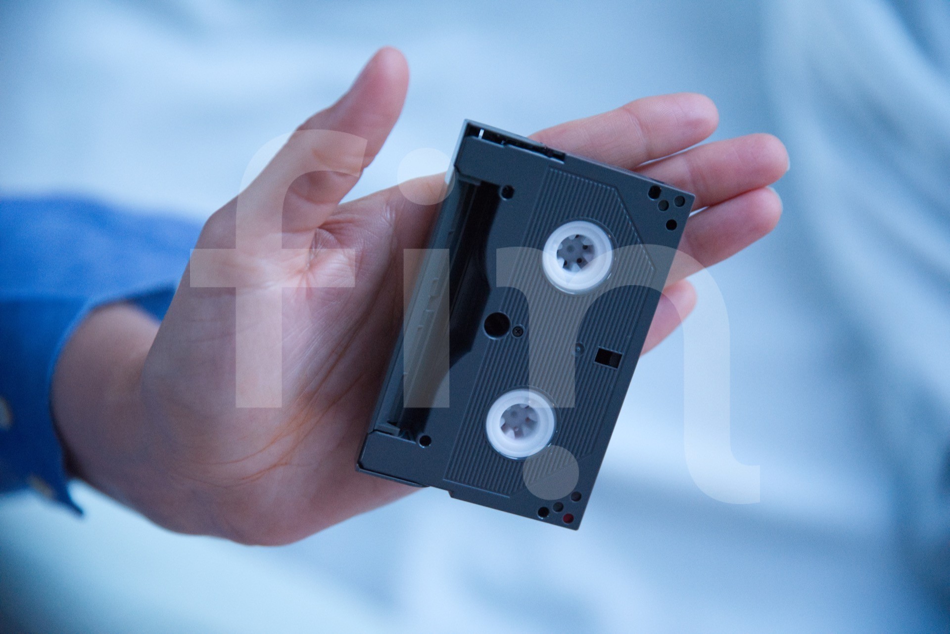 Small videotape in hand