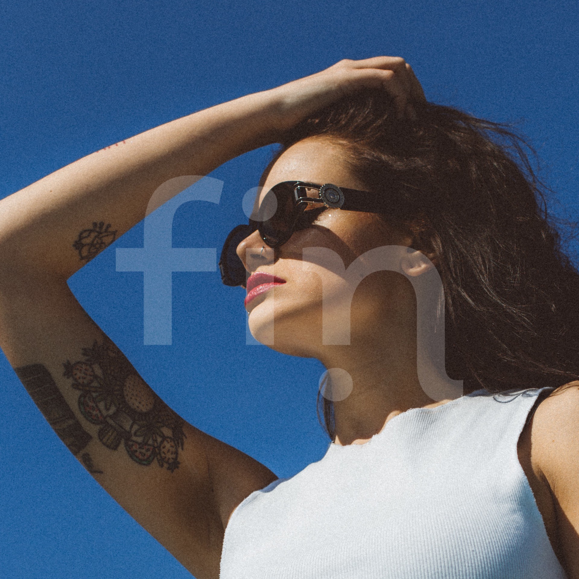 Girl with arm tattoo and sunglasses lower perspective square format