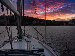 Bow of a sailboat with sunset