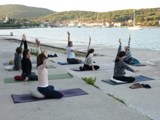 People practice yoga on the beach shore