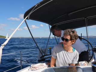 Woman with sunglasses on a sailboat sails the sea