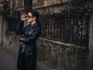 Black coat fashion girl with sunglasses and dark makeup on the street
