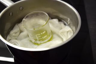 Dissolving the oil in a warm bath in a laboratory beaker