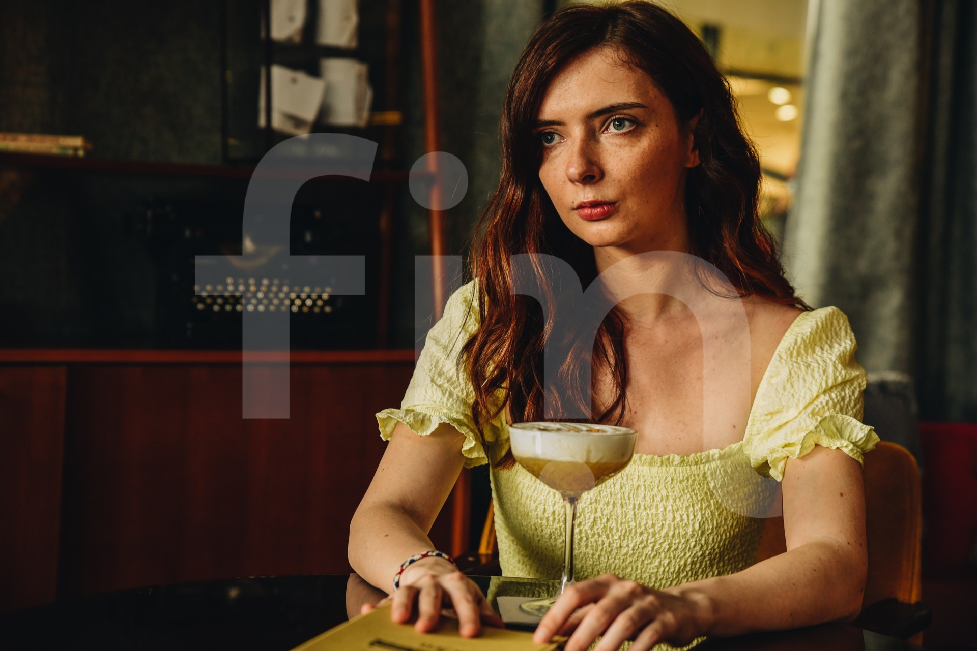 Girl with a cocktail is sitting at a table vintage antique interior