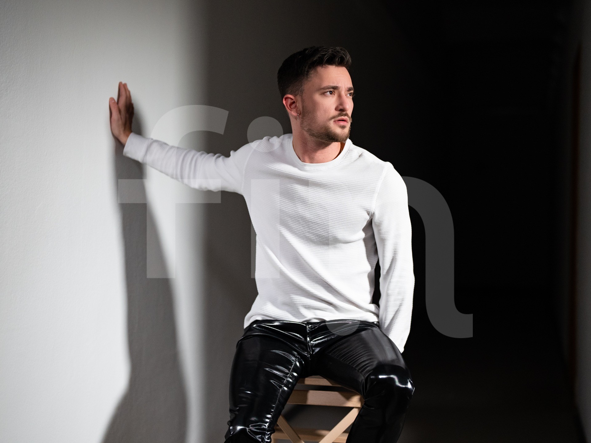 Handsome young guy in white shirt and latex fashion pants