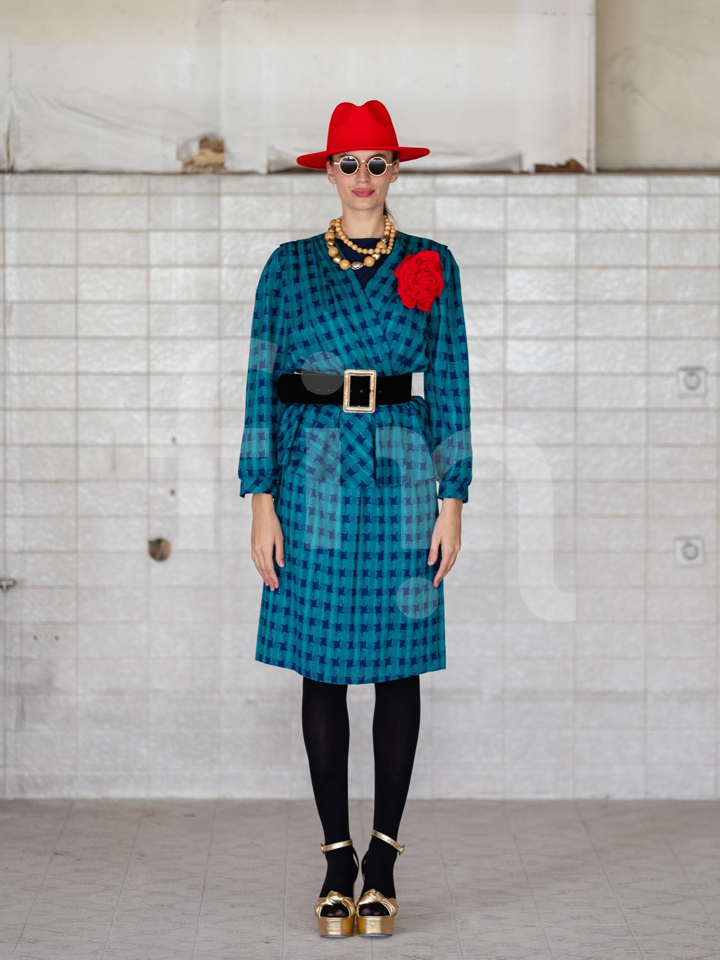 Retro girl with a red hat and a belt at the waist wearing sunglasses