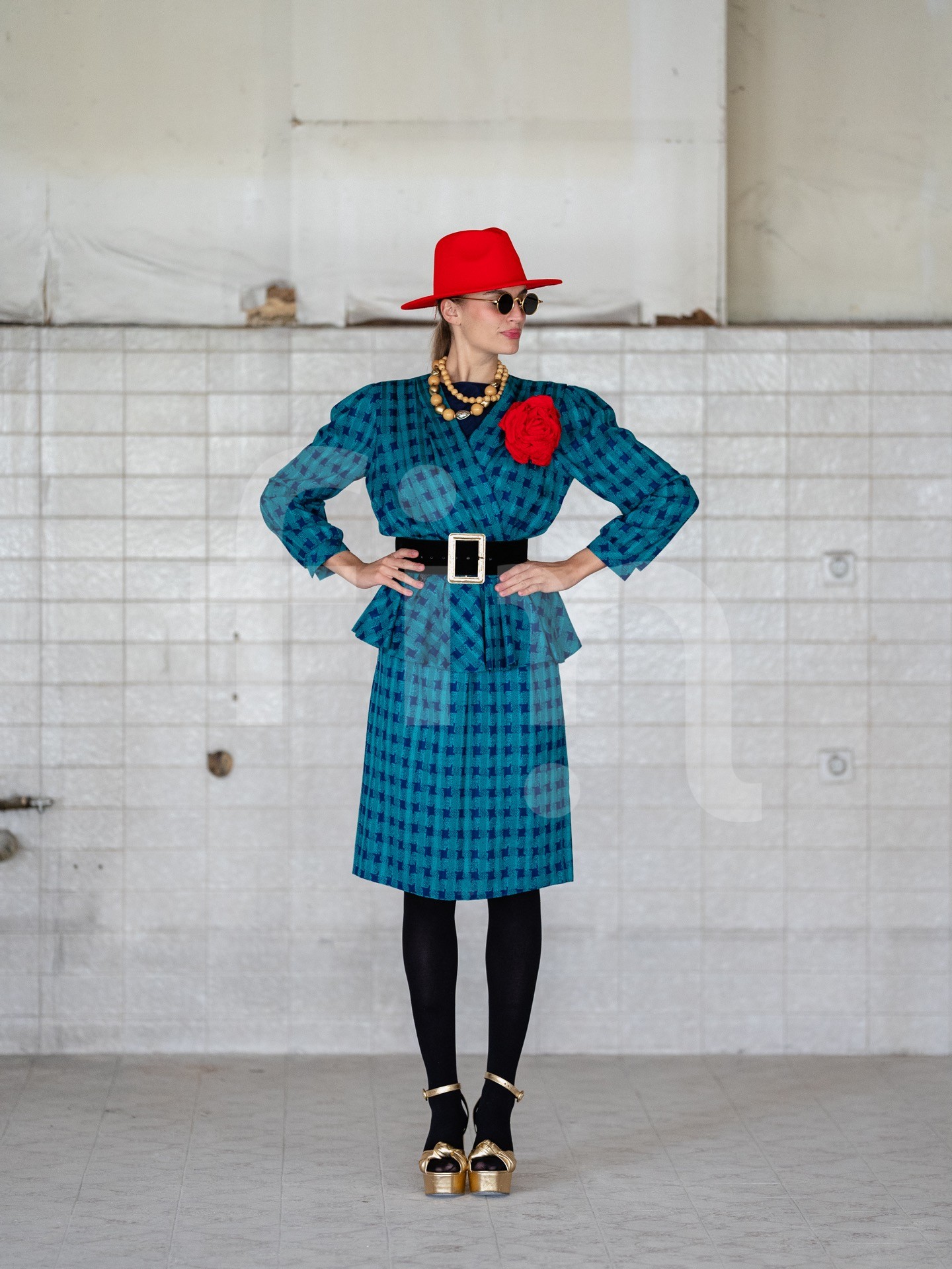 Retro girl with a red hat and a belt at the waist wearing sunglasses