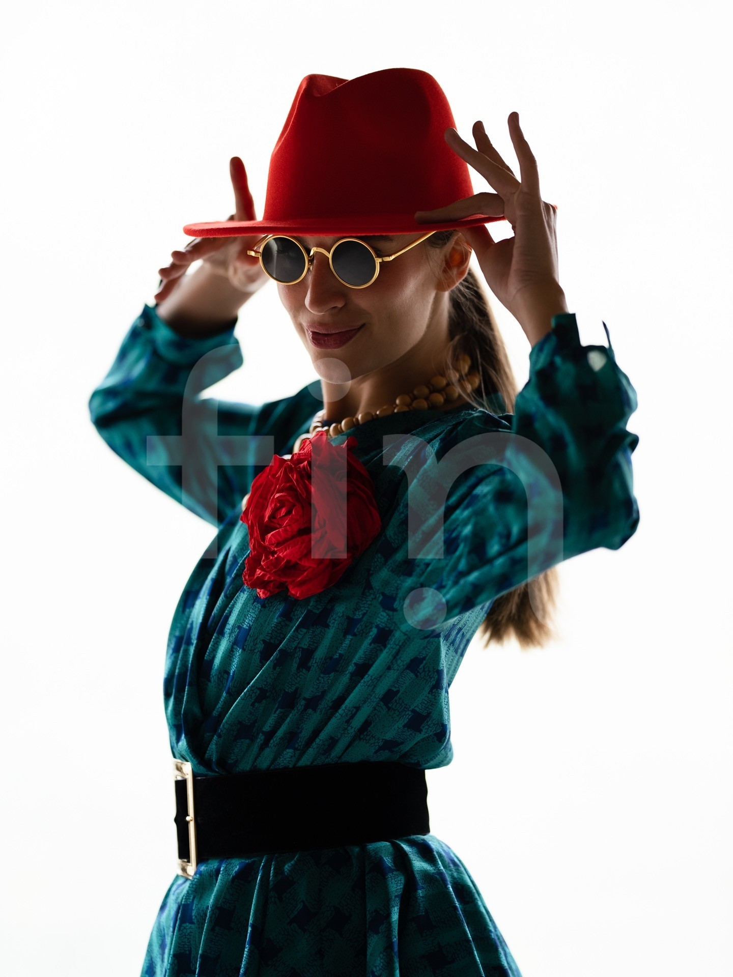 Retro girl with a red hat and a belt at the waist wearing sunglasses
