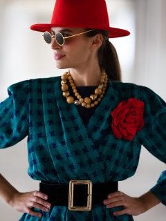 Retro girl with a red hat and a belt at the waist wearing sunglasses