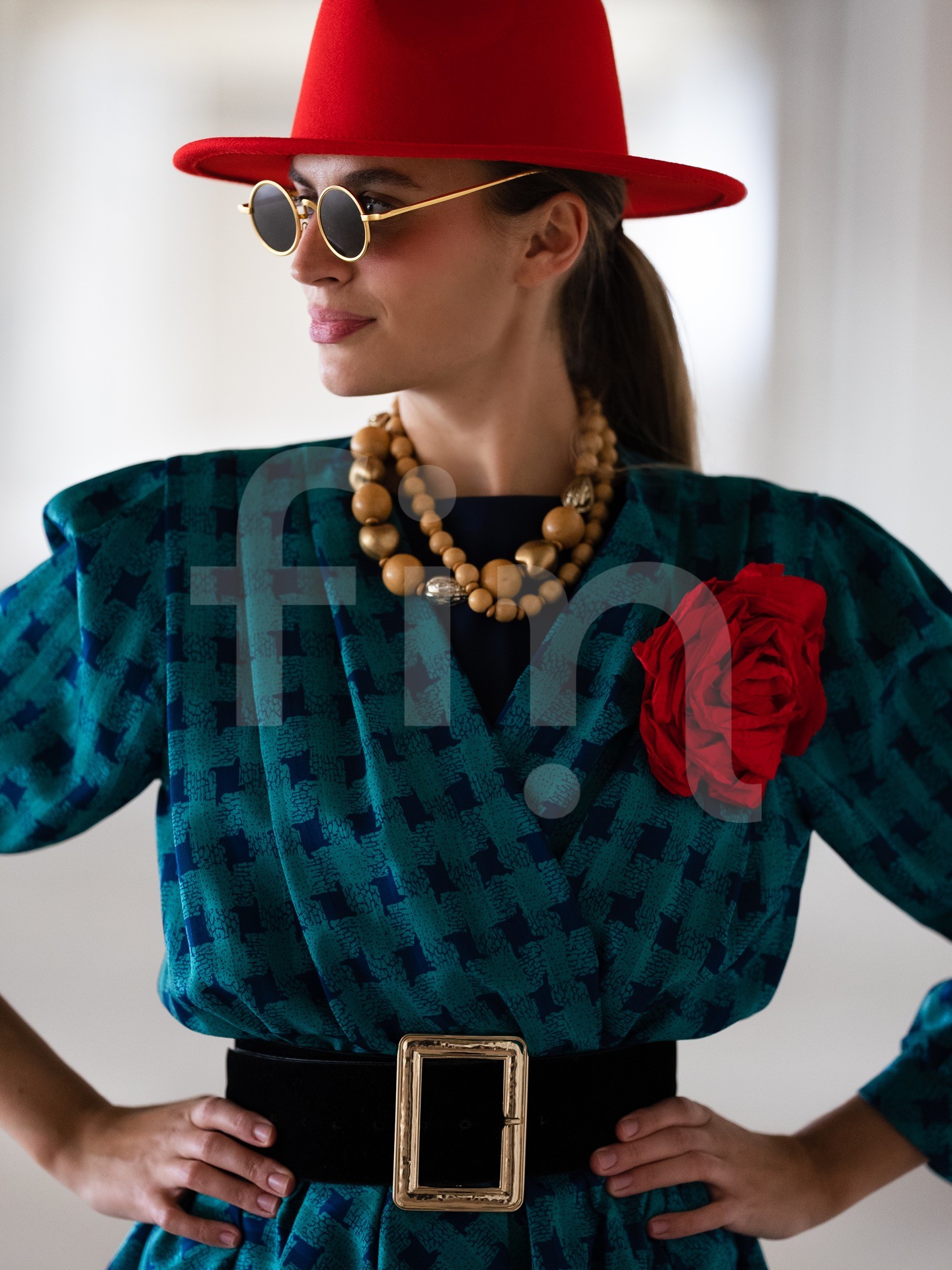 Retro girl with a red hat and a belt at the waist wearing sunglasses