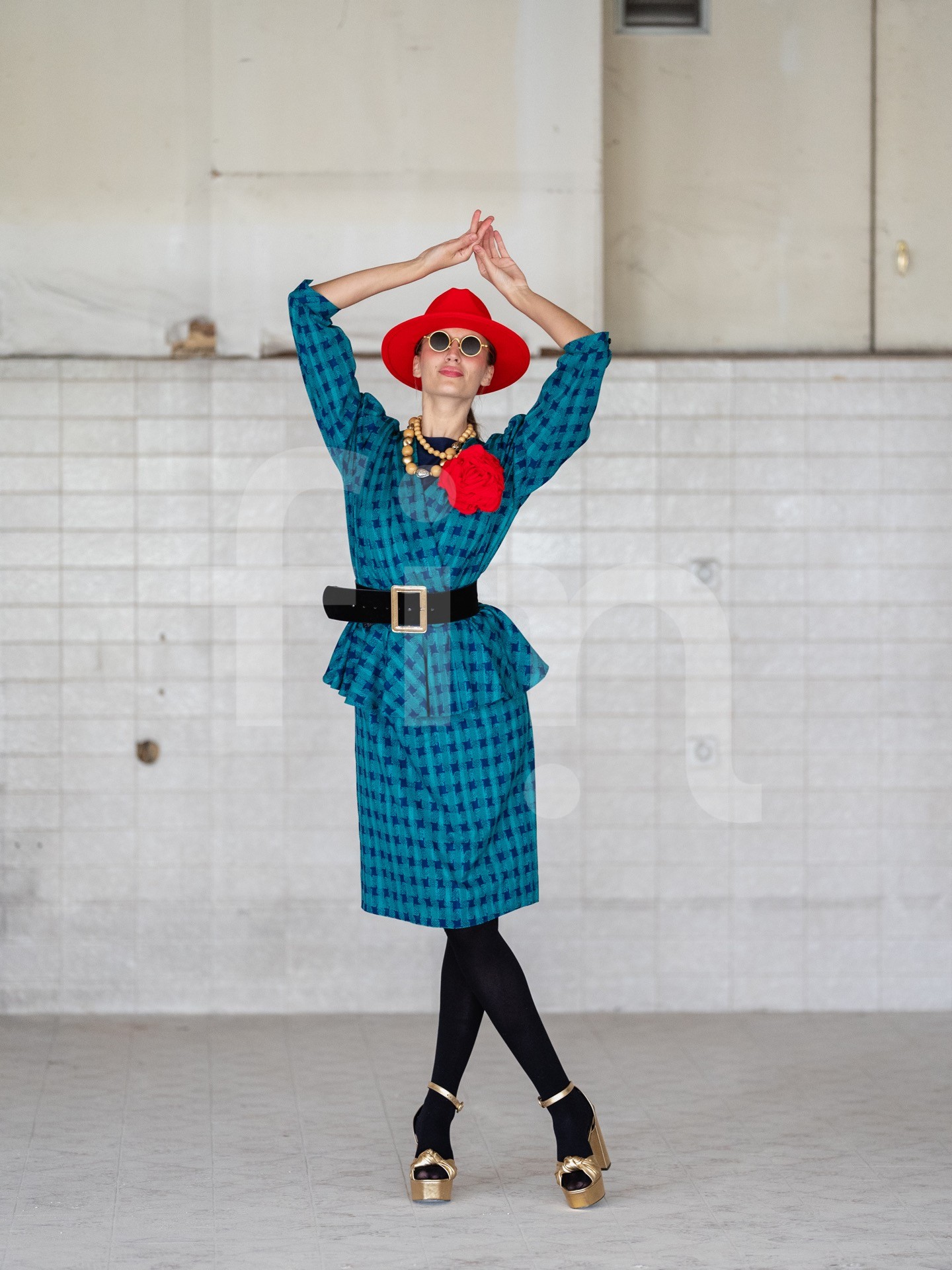Retro girl with a red hat and a belt at the waist wearing sunglasses