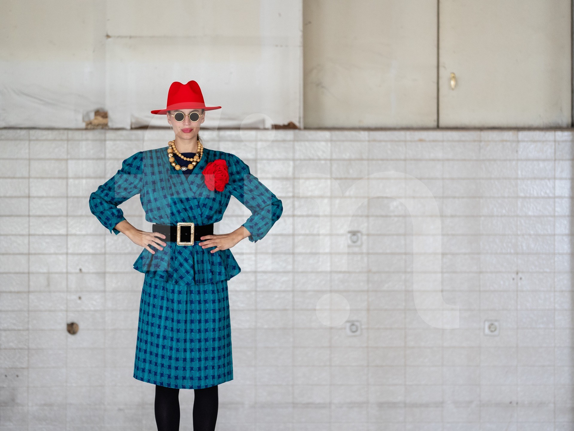 Retro girl with a red hat and a belt at the waist wearing sunglasses