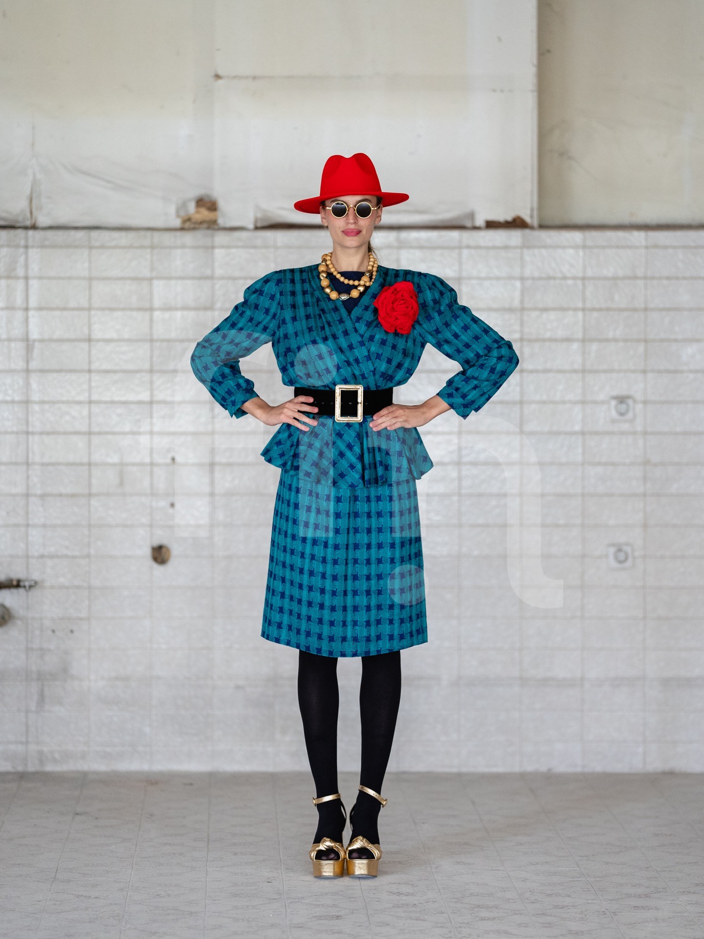 Retro girl with a red hat and a belt at the waist wearing sunglasses