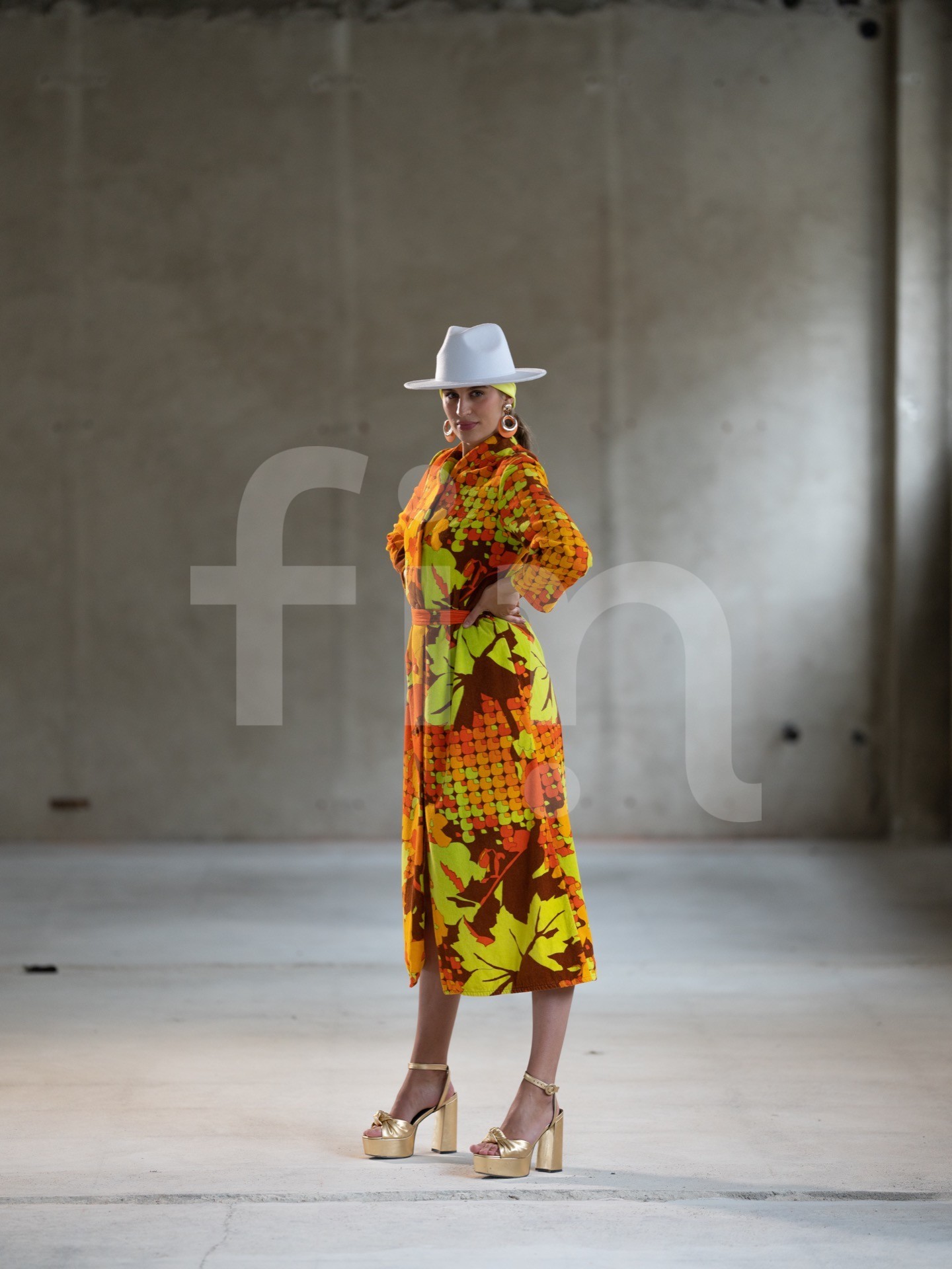 Yellow-orange styling girl in a spacious concrete hall